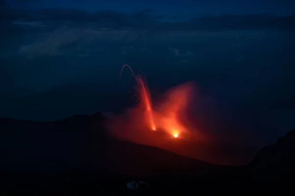 Red glowing lava eruption of volcano Stromboli during night, Sicily Italy