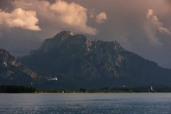 Hrad Neuschwanstein Jezerem Forggensee Horami Při Západu Slunce Dramatické Mraky — Stock fotografie