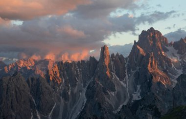 Avrupa Dolomit Alpleri 'ndeki dağ manzarası, gün batımında alp alfabesiyle parlayan Üç Tepe' nin altı, gökyüzünde renkli bulutlar, Güney Tyrol İtalya