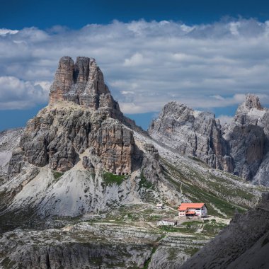 Dağ zirvesi Sasso di Sesto ve Dolomite Alplerinin doğa parkında üç tepe kulübesi, Rifugio 'da güneş ve gökyüzünde bulutlar, Güney Tyrol İtalya