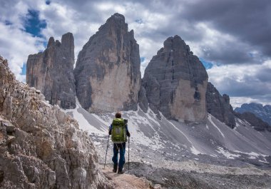 Sırt çantalı bir adam Avrupa Dolomit Alpleri 'ndeki Üç Tepe' yi geziyor, gökyüzünde bulutlar, Güney Tyrol İtal