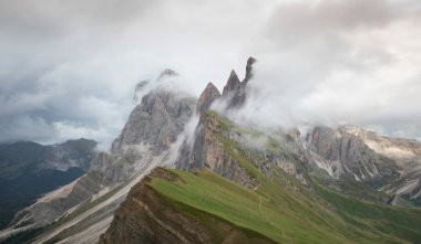 Avrupa Dolomite Alpleri 'nde Seceda' nın dik uçurumlarında ve dağ zirvelerinde yoğun bulutlarla dramatik hava, Güney Tyrol İtalya