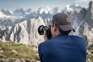 DSLR kamerasıyla fotoğraf çeken bir adam, Dolomite Alplerindeki dağ manzarası gündüz vakti Three Peaks 'te, arkadan manzara, Güney Tyrol İtalya