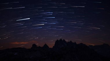 Dolomite Alplerindeki Three Peaks 'te gece gökyüzünde yıldız izleri olan dağ siluetleri, Güney Tyrol İtalya