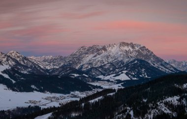 Fieberbrunn 'daki dağlık Wilder Kaiser dağları. Kışın gün batımında kar, orman ve vadi, gökyüzünde bulutlar, Tyrol Avusturya.