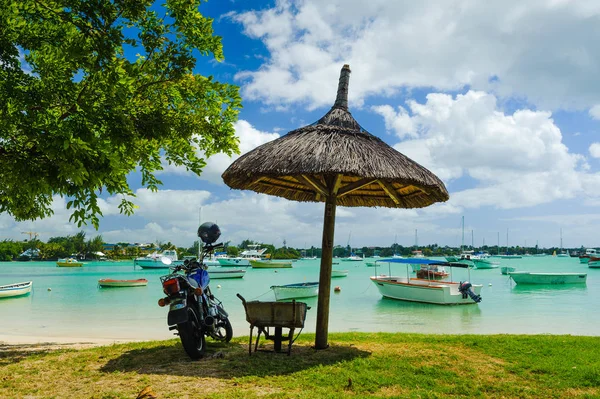 Hafen mit Fischerbooten, Yachten, Motorrädern und Sonnenschirm im Vordergrund. Mauritius — Stockfoto