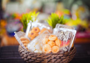 Tanımlama bilgileri ve rengarenk, renkli arka plan üzerinde bir hasır ahşap sepeti hamur işleri ile plastik tek kullanımlık kaplar