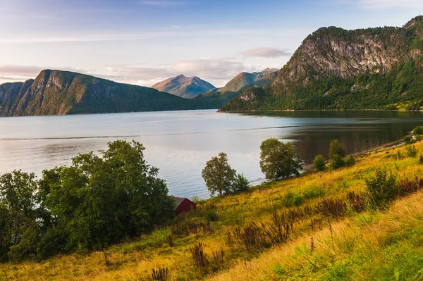 Fiyort güzel manzarasına parlak bir günbatımı gökyüzü arka plan üzerinde. Norveç — Stok fotoğraf