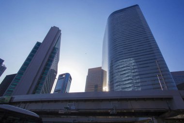 Ginza ilçesi yakınlarındaki gökdelenler ve Hamarikyu bahçeleri; akşam mavi gökyüzü;