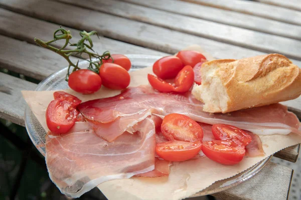 Jamón de parma, tomates y un trozo de baguette . — Foto de Stock