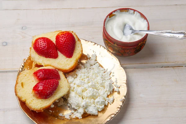 コテージチーズ サワークリームとイチゴと白い木製のテーブルの上のケーキとサンドイッチ — ストック写真