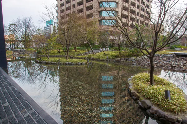 Japanese garden in  Osaka with pond at end of March.   Downtown