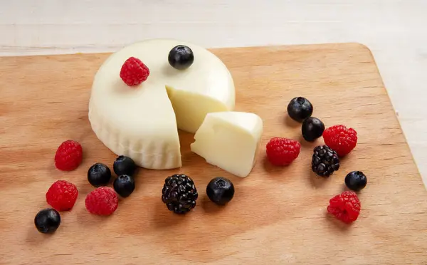 茶色の机の上の柔らかいチーズとベリー 健康食品 ミルク製品 — ストック写真