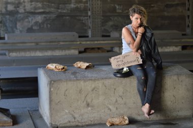 alcohol addicted, homeless woman with emptied bottled alcohol in brown paper bags next to her begging for money holding a sign - are you my neighbor?  clipart