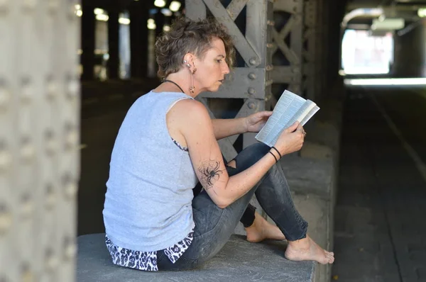 Πανκ Γυναίκα Κάθεται Κάτω Από Μια Γέφυρα Και Διαβάζοντας Μια — Φωτογραφία Αρχείου