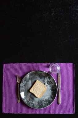 yemek az oruç içinde olan bir dilim ekmek ve bir tabak ve bardak su