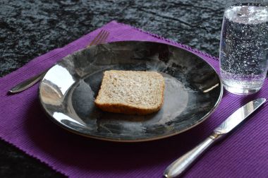 yemek az oruç içinde olan bir dilim ekmek ve bir tabak ve bardak su