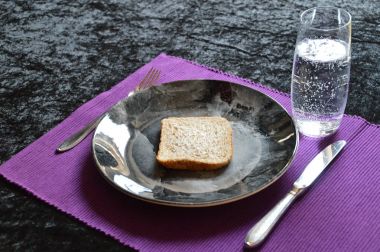 yemek az oruç içinde olan bir dilim ekmek ve bir tabak ve bardak su