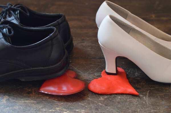 The shoes of a husband and a wife stepping on each others hearts