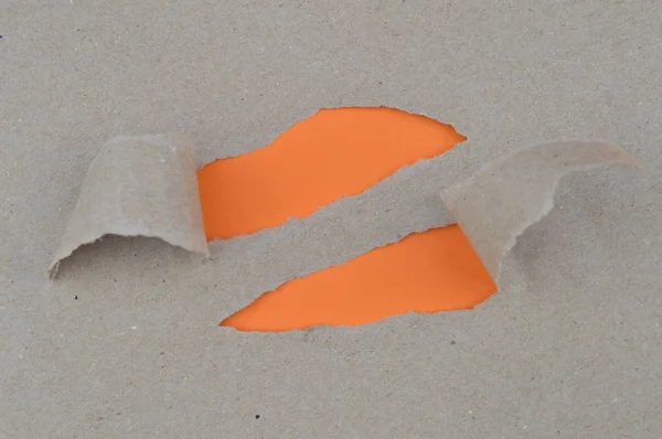 craft paper ripped open at two places showing blank orange paper below with space for a message
