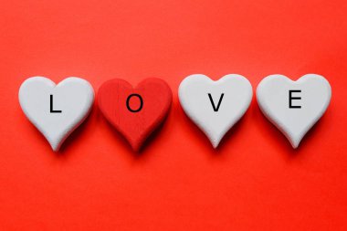Üstten Görünüm ahşap beyaz ve kırmızı kalp simgesi 'Aşk ile' kırmızı zemin üzerine yazılmış olmasını. Valentine's day Tema.