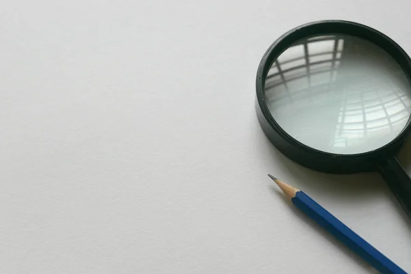 Penna och förstoringsglas på vitt papper bakgrund. Kopiera klistra för text, logotyp och etc.. — Stockfoto