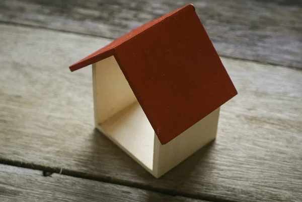 Casa de madeira com telhado vermelho no fundo de madeira . — Fotografia de Stock