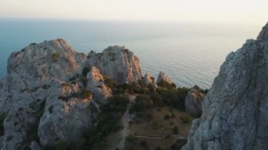 Drone uçuş batımında denize bakan kayalar arasında.