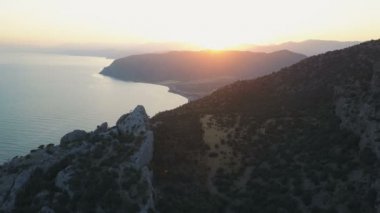 Kayalar ve Kırım'da günbatımında dağlarla çevrili güzel Körfezi üzerinde uçuş
