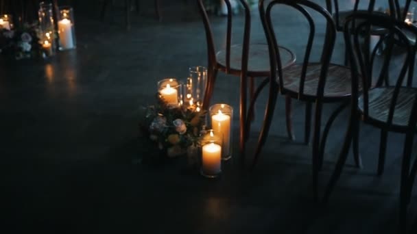 椅子に近づく別の花の美しい花束とキャンドルを燃焼. — ストック動画