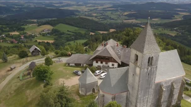 Vuelo sobre la antigua iglesia en una montaña. Vista aérea de Magdalensberg, Carintia, Austria. Hermosas montañas en el horizonte . — Vídeos de Stock