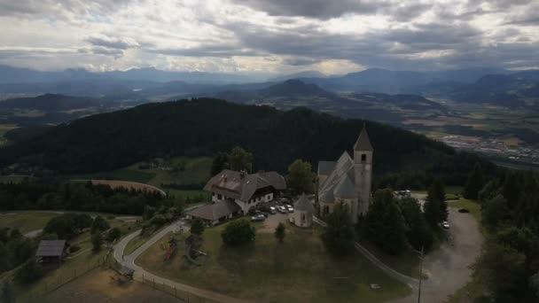 Flug über der antiken Kirche auf einem Berg. Luftaufnahme von Magdalensberg, Kärnten, Österreich. Schöne Berge am Horizont. — Stockvideo