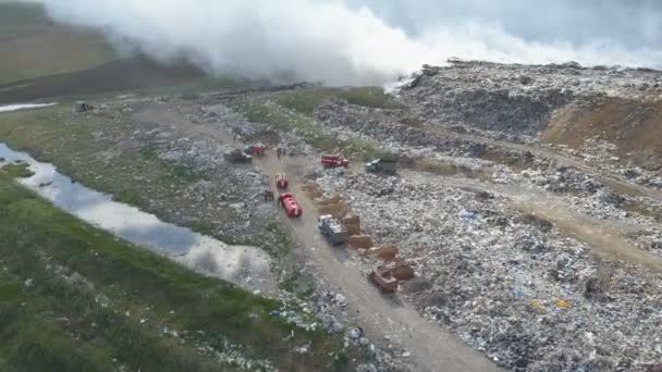 O depósito de lixo polui o ambiente. Vento forte sobe fumaça tóxica de lixo queimado no ar . — Vídeo de Stock