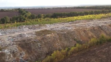 Aerial view of large garbage pile at sorting site. Flight along huge mountain of waste from consumerism household. Environmental pollution, Garbage pile in trash dump.