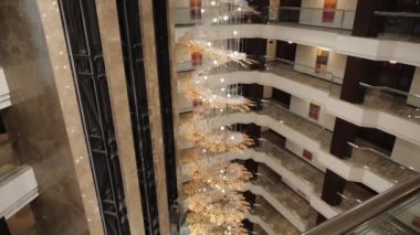 Zeminden aşağıya, balkonlara ve otelin birçok kapısına bakın. Güzel, pahalı bir otel, koridorun ortasındaki asansör. Yavaş çekim.