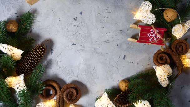 Cône de branche de pin petites noix traîneau reposent sur la table. De belles mains féminines déplacent un cadeau attaché avec une corde pour le Nouvel An et les décorations de Noël. Vacances approchant au ralenti. Vue ci-dessus — Video