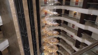 Kharkiv, Ukrayna - 01 Kasım 2019: Kharkiv Palace Premier Hotel 'in içi. Rahat, pahalı bir otel, salonun ortasında bitki yaprakları şeklinde güzel bir avize..