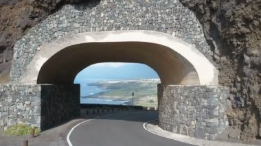 Tünelden uçmak. İnsansız hava aracı bir kayanın içinden geçiyor. Punta del Fraile, Tenerife, Kanarya Adaları, İspanya