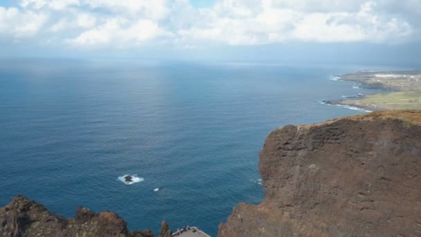 Flygfoto över branta klippor över Atlanten. Flyg över människor som beundrar fin utsikt från observationsdäcket Punta del Fraile, Teneriffa, Kanarieöarna, Spanien. — Stockvideo