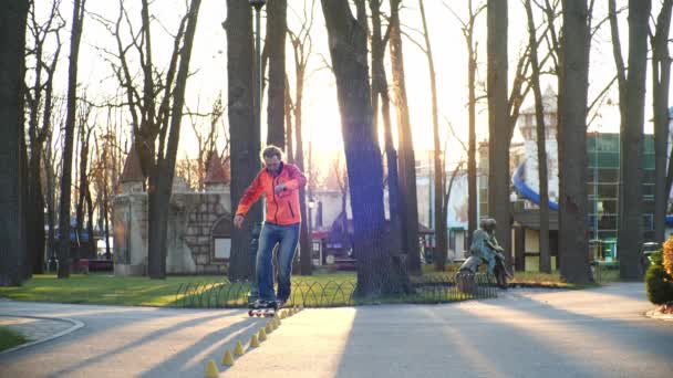 Професійний ролик з відмінною технікою їзди та хорошою розтяжкою робить складні повороти навколо шишок для тренувань у прохолодному осінньому парку. Вид знизу у повільному русі. Здорове життя . — стокове відео