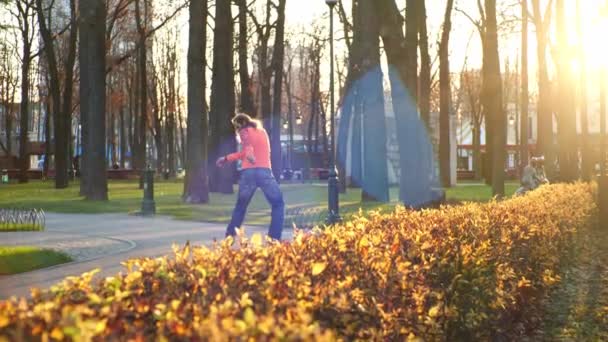 L'uomo attivo e atletico esegue una tecnica professionale di pattinaggio a rotelle in un parco cittadino fresco. Un esperto pattinatore a rotelle in autunno all'aria aperta in un parco tra gli alberi al rallentatore . — Video Stock