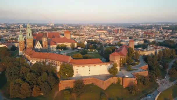 Luchtfoto van de Koninklijke Wawel-kathedraal en het kasteel in Krakau, Polen, met de Vistula-rivier, Park, tuin en toeristen bij zonsondergang. Oude stad op de achtergrond — Stockvideo