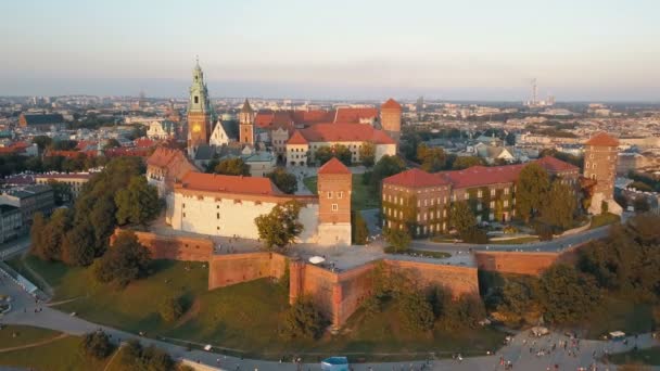 Letecký pohled na královskou Wawel katedrálu a hrad v Krakově, Polsko, s Vistula řeka, park, dvůr a turisté při západu slunce. Staré město Evropy v pozadí. — Stock video