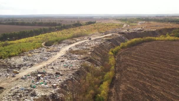 Luftaufnahme von Lastwagen, die Abfall auf einen Müllhaufen in einer Müllhalde bringen. Großer Müllberg am Sortierplatz. Umweltverschmutzung durch Konsum. Abfallbehandlung auf einer Müllhalde. — Stockvideo