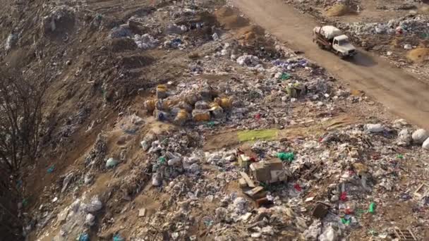 Vlucht over vrachtwagens die afval naar een vuilnisbelt in de vuilnisbelt brengen. Luchtfoto van grote vuilnishoop op de sorteerplaats. Milieuvervuiling door consumentisme. Afvalverwerking op een vuilnisbelt. — Stockvideo