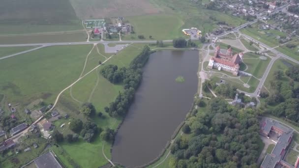 Повітряний постріл квадрокоптером Мирського замку в Білорусі сповільнив рух. Озеро розташоване недалеко від замку Мир. Стародавні та гарні пам "ятки Білорусі, рекомендовані для відвідин. — стокове відео