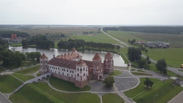 Повітряний круглий постріл над Мирським замком у Білорусі. Дивовижний вигляд старої будівлі з історією, яка знаходиться недалеко від озера і серед дерев. Передня частина замку в повільному русі.. — стокове відео