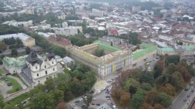 Lviv 'deki St. Michael Yalınayak Carmelite Kilisesi yavaş çekimde yukarıdan görülüyor. Tarihi ve güzel Ukrayna şehri. İnsansız hava aracı Lviv 'in merkezindeki eski evleri vuruyor..