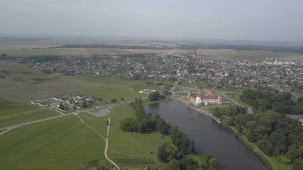 Schot van boven het dorp Mir en Mir Castle in Wit-Rusland in slow motion. Oude trots en zicht in de herfst vanuit vogelperspectief. Panorama van een klein dorp en een oud gebouw, bovenaanzicht. — Stockvideo
