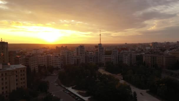 Derzhprom contra o pôr-do-sol brilhante à noite na Ucrânia. O edifício histórico de Kharkov na Praça da Liberdade. Boa noite no centro da cidade, ainda a disparar. Últimos dias de outono . — Vídeo de Stock